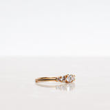 Mumbaistockholm Fine Jewelry Ring: Elise Ring in 18K yellow gold with five white, conflict-free diamonds. The center diamond is 0.25 CT, and on each side are two 0.11 CT diamonds, and two 0.04 CT diamonds. Pictured from the side.